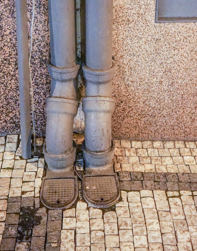 Services a-close-up-of-a-pair-of-metal-pipes-on-a-tiled-floor-07qoiorarde
